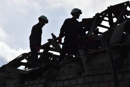 Διασώστες σε ερείπια κατεστραμμένων σπιτιών
